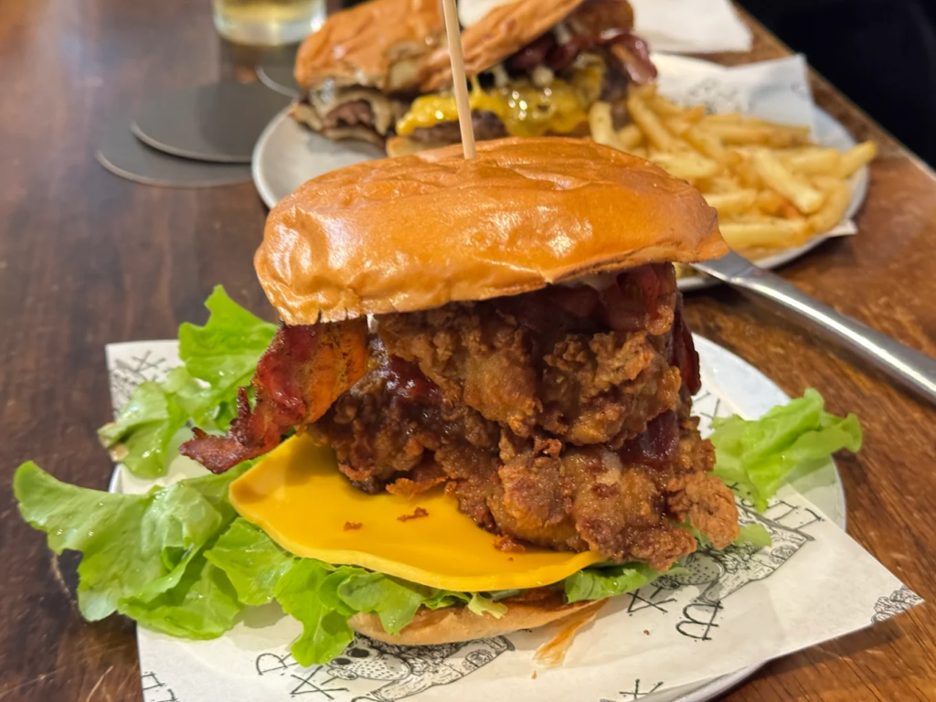 The famous Blame Canada burger and poutine loaded fries on a wooden table at Bar Luca in the Sydney CBD.